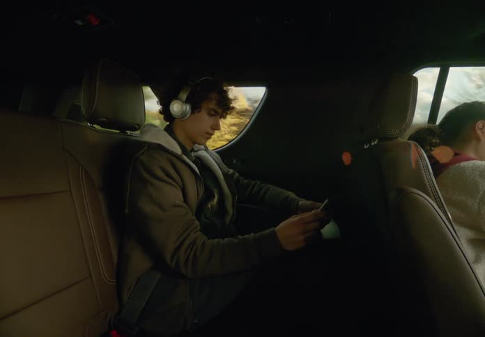 Two people are driving in a car during the spring time