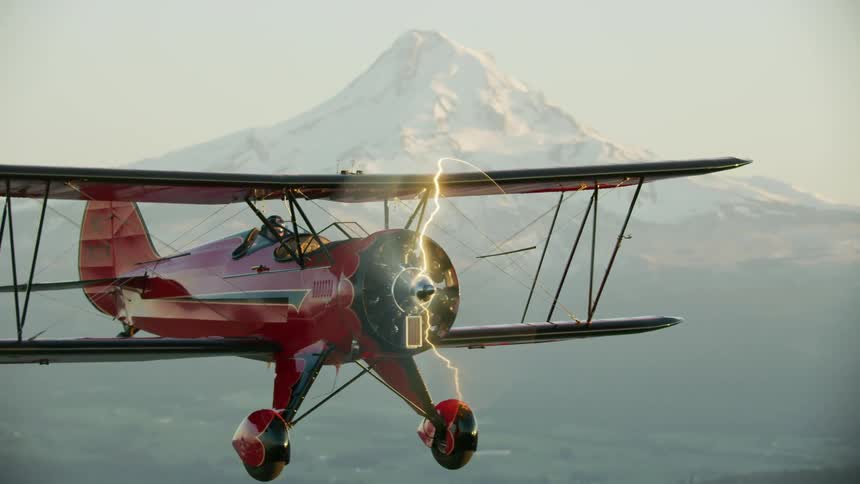 Red light aircraft flies high in the sky with a majestic snow covered mountain in the backgound