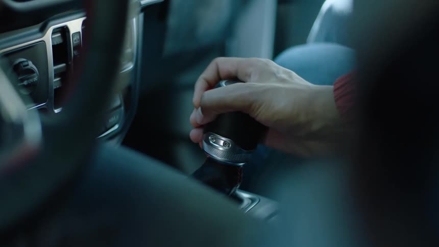 A person is pulling the gear shift