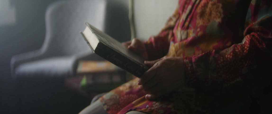 Woman sitting in public transport closes the book she was reading
