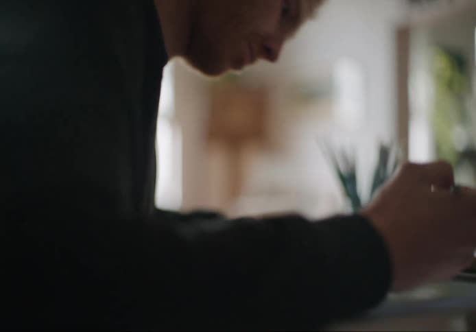 A man is sitting at a table writing on paper