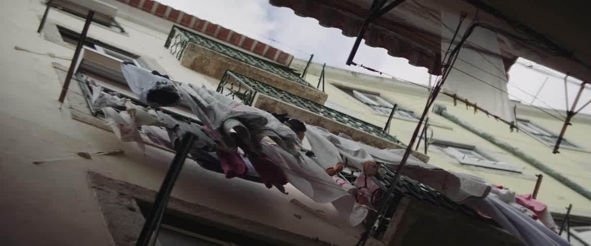 There are clothes hanging on a clothing line outside in the middle of the day time