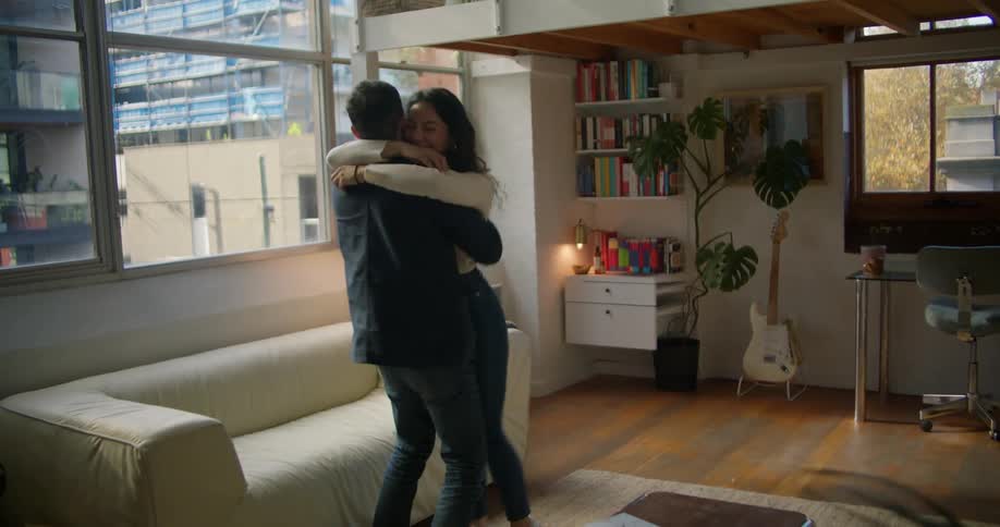 Young couple hug in celebration after finishing cleaning their new apartment