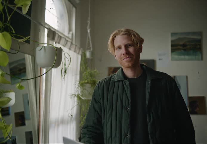 Portrait of a man standing in a plant filled room and smiling