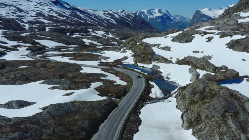 A car is driving on a road through an arctic area