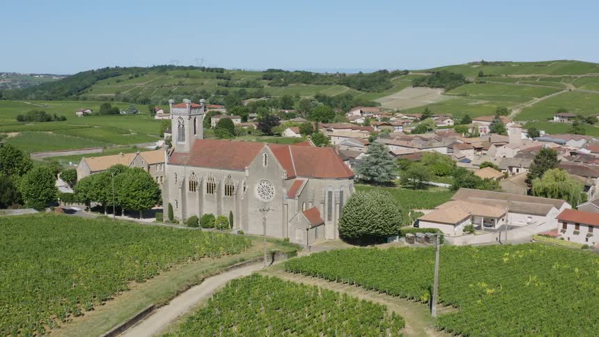 A large church in a small town in a hilly countryside on a clear day