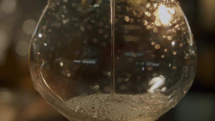 Bubbles form as wine pours from a bottle into a glass
