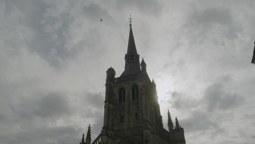 The view is of a building and birds flying around it in the day time