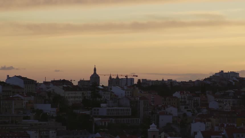 Aerial view of the sun setting in the horizon of an urban city