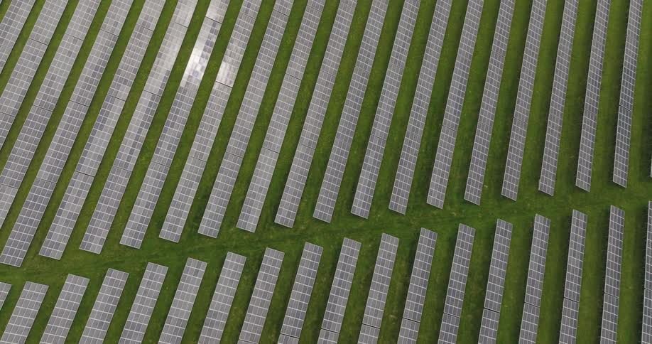 The sun shines on solar panels on a solar farm