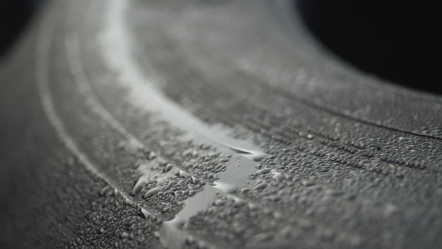 The pebbled surface of rubber with water droplets shimmering