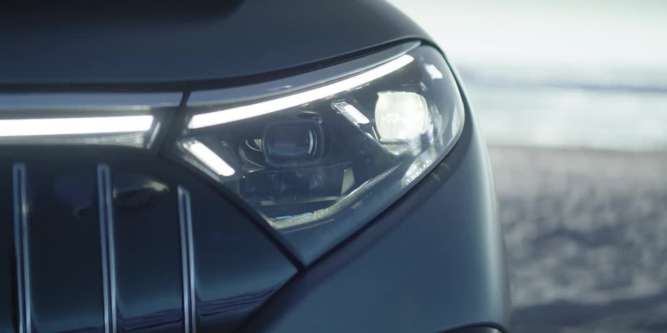 The headlights of a black automobile turn on