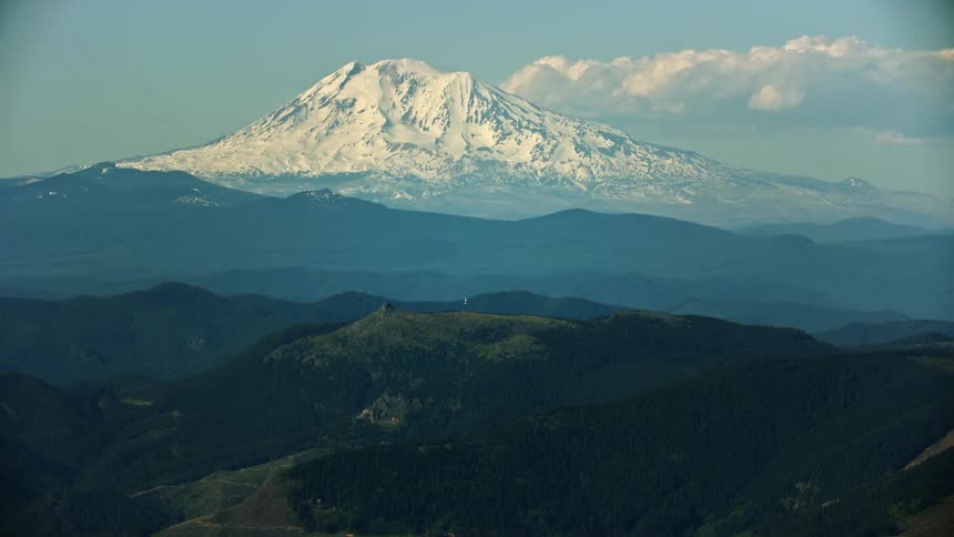 Mount Adams rises high above the Gifford Pinchot National Forest in this medium shot high altitude aerial