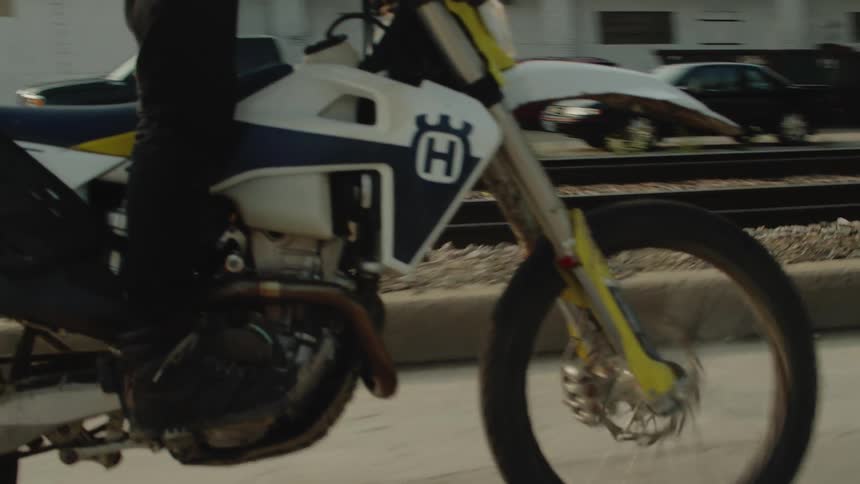 A person is driving a motorcycle on a street in a city