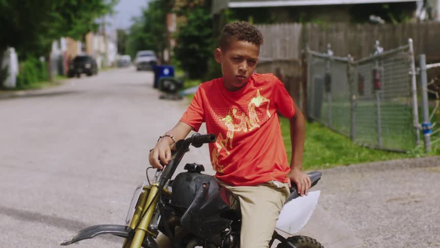 A child is riding a bike through a neighborhood
