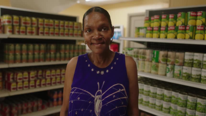 A female employee is standing in a grocery aisle