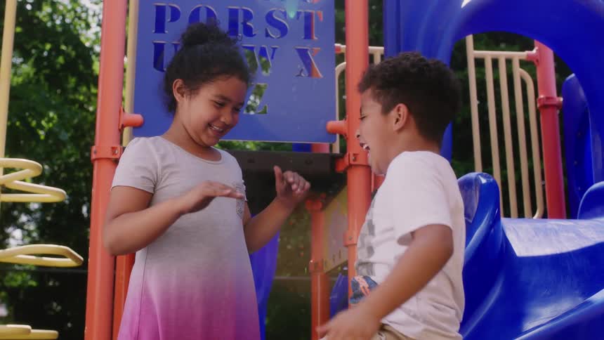 Two children are playing together at a playground in spring