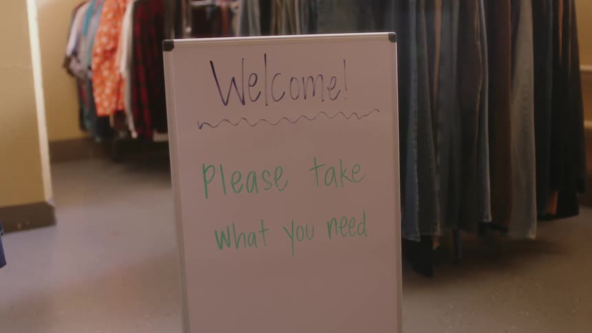 A sign is displayed in a clothing store