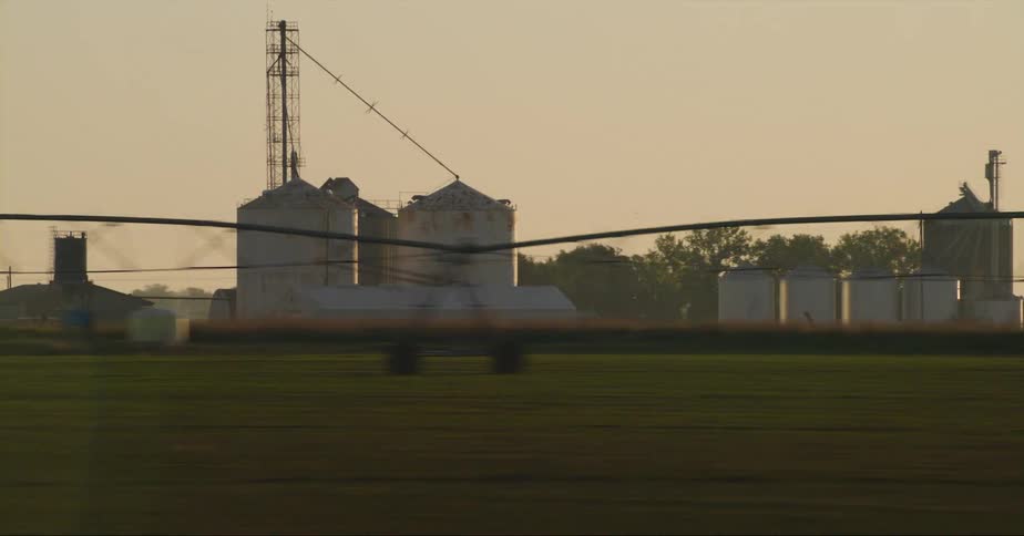 Several clusters of silos sit on farm bordered by fence