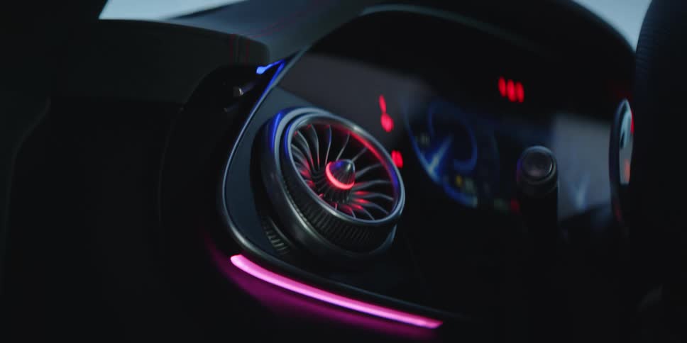 Close up of the bright colorful lights on the futuristic shiny black console of a luxury vehicle