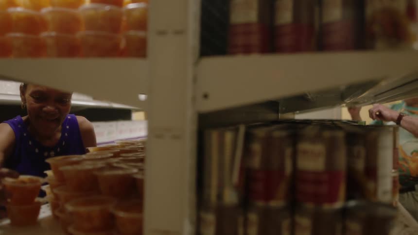 Employees and customers are looking at products in a grocery store