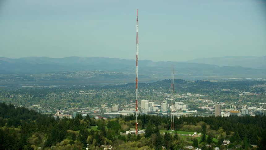 Radio towers and antennae stand tall in the foreground of this sweeping high altitude aerial of Portland Oregon in late Spring