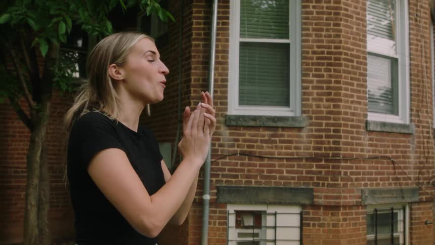 A woman is standing outdoors and cheering