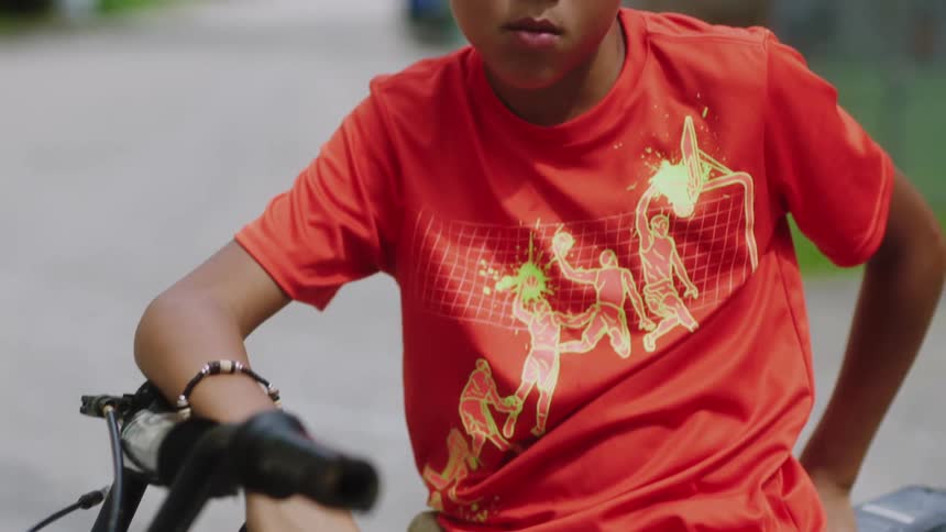 A child is sitting on a bike outdoors in spring
