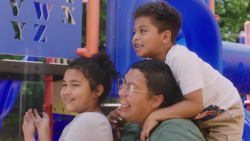 A mother is at a park with her two children