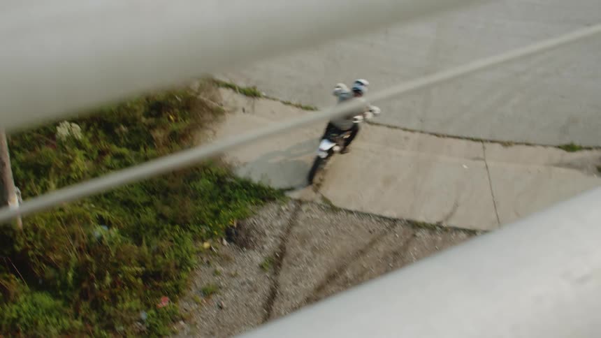A man is driving a motorcycle on a street in a neighborhood