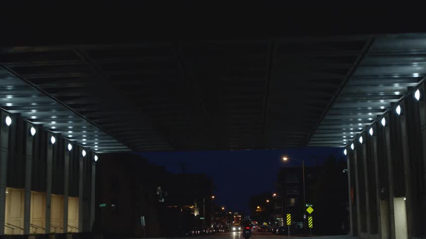 Traffic moves in a tunnel through a building in a city