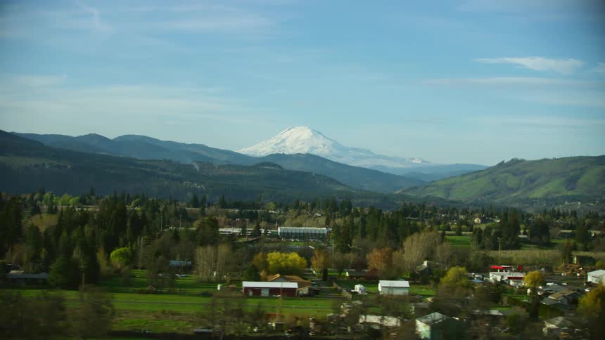 Mount Adams blanketed with a vast layer of snow stands high above the picturesque town of Hood River from the POV vantage of an airplane window upon landing