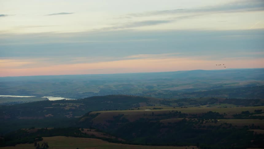 Five backcountry aircraft flying over lush green land at sunrise on the way to the backcountry