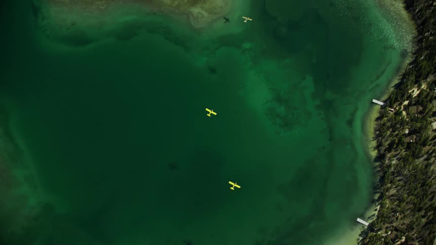 Aerial of yellow backcountry airplanes flying over Redfish Lake near Stanley, Idaho