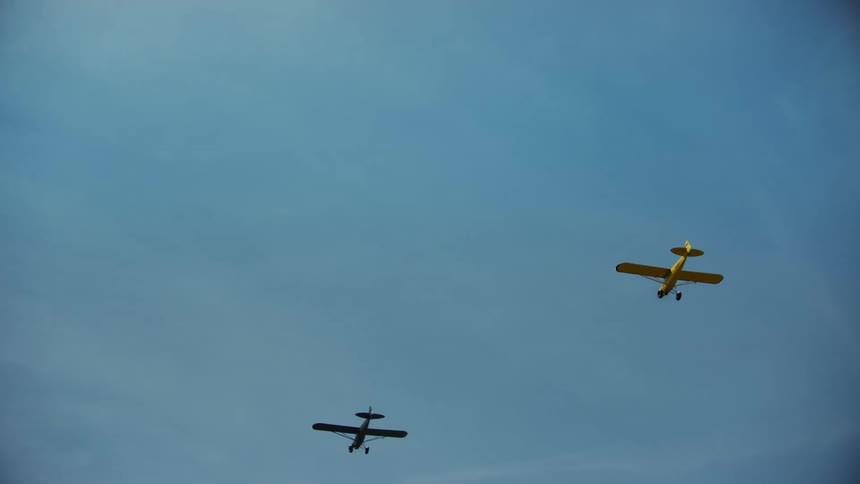 Looking up at several backcountry carbon cub aircraft in the alpine sky