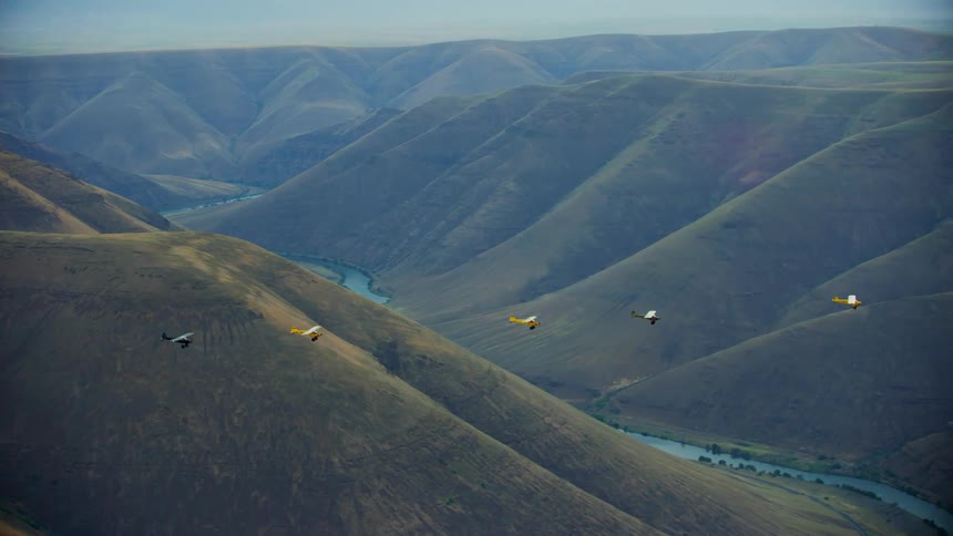 A group of small backcountry airplanes fly over the Deschutes River Canyon