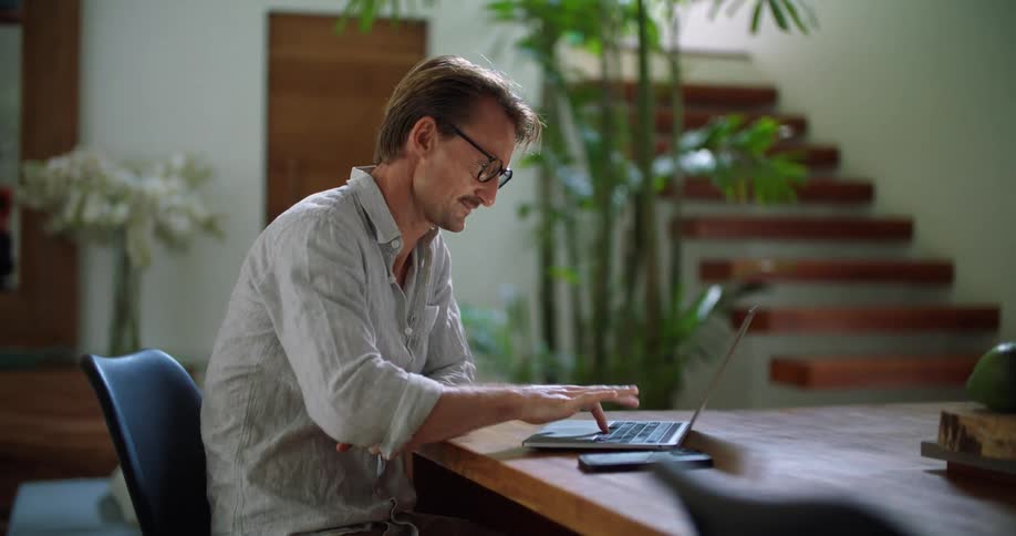 A man waves and says goodbye to his video call closes the laptop and sighs