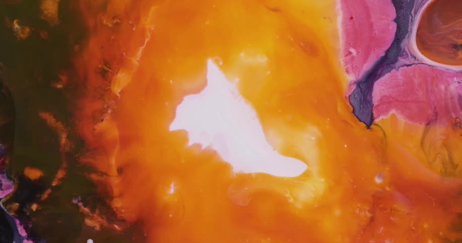 A bright whiteness is inside orange as it moves over pink and black liquid colors