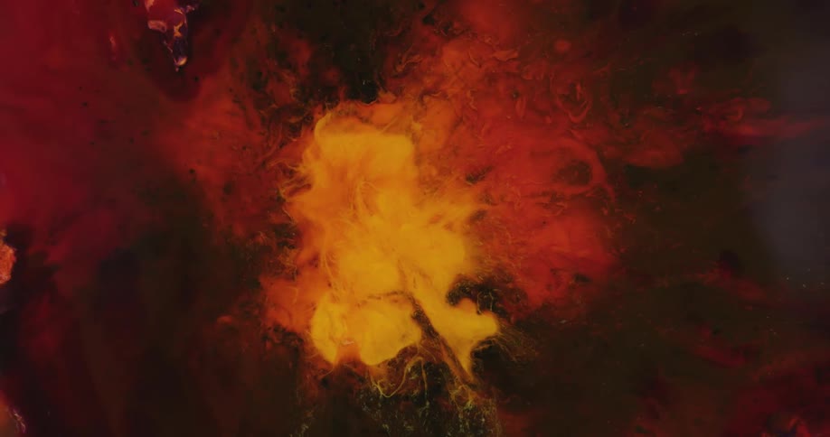 Flaming red and orange liquid colors slowly move in the darkness