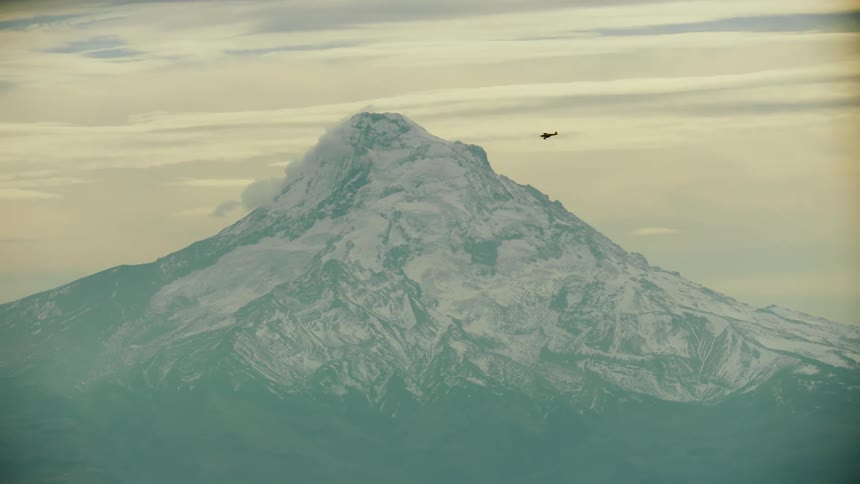 A Backcountry Carbon Cub airplane passes in front of Mount Hood in Oregon