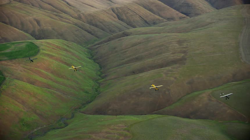 Aerial view of backcountry single engine aircraft flying over the rolling hills of the Palouse dryland wheat farmland