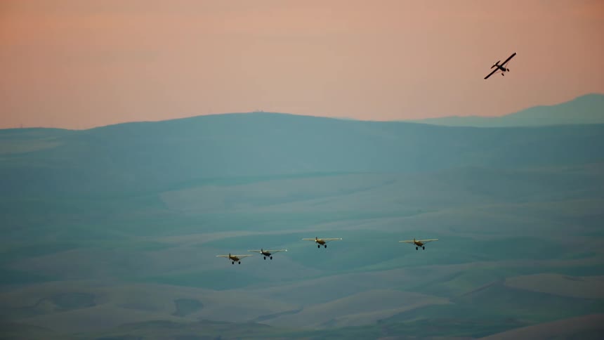 Five backcountry airplanes fly in formation into the sunrise sun