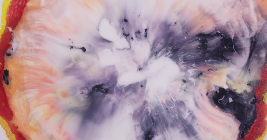Bright blue and yellow liquid ink blooming and spreading over a white background