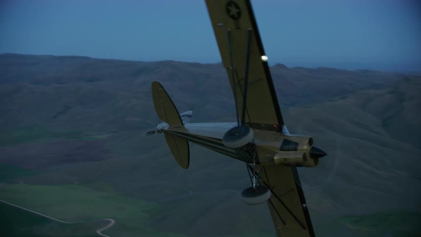 Two small Carbon Cub airplanes break formation and dive into the evening sky