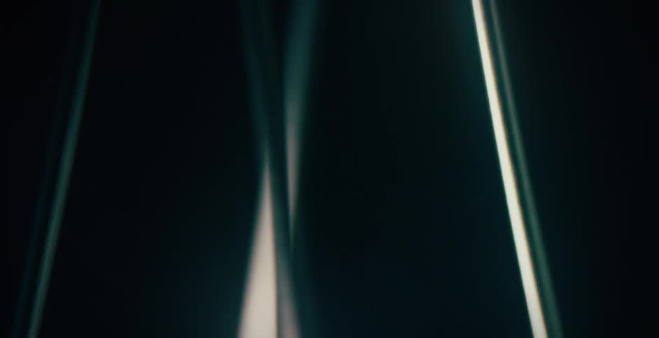 Thin vertical spinning blades circling around in front of a black background