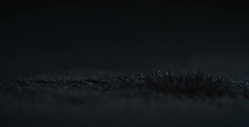 Dark fibers move one by one in a ripple like effect in the darkness