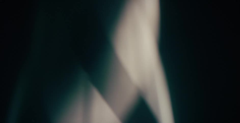 Wisps of light are twisting and moving upward in the darkness