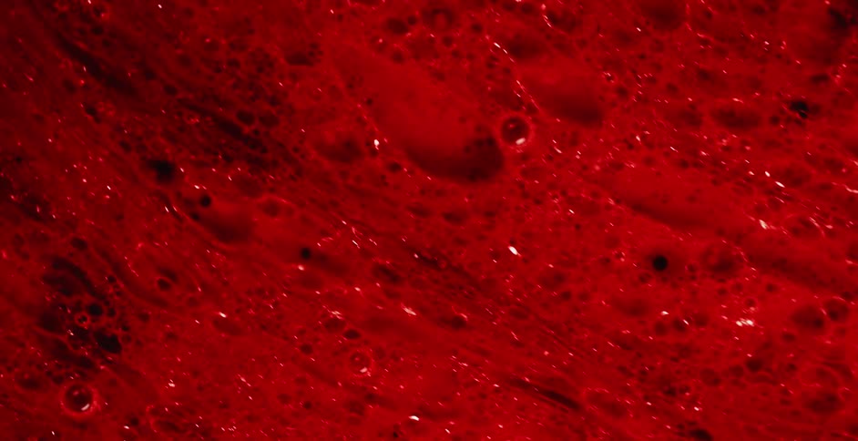 Liquid with bubbles and craters moves by like a martian surface
