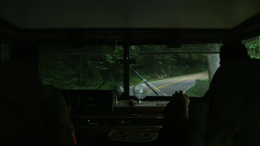 People driving down a wooded road