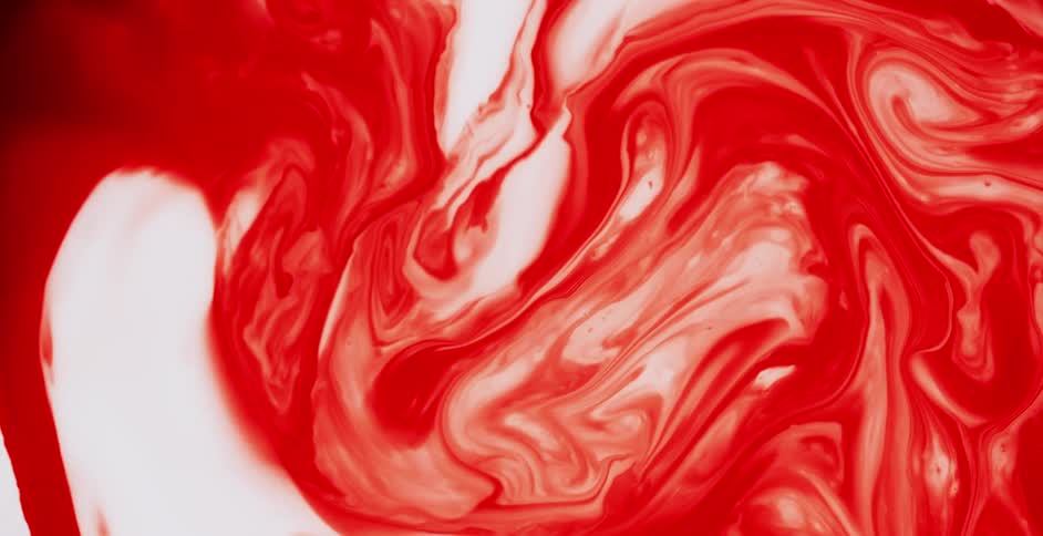 Red and white paint mixing and swirling together